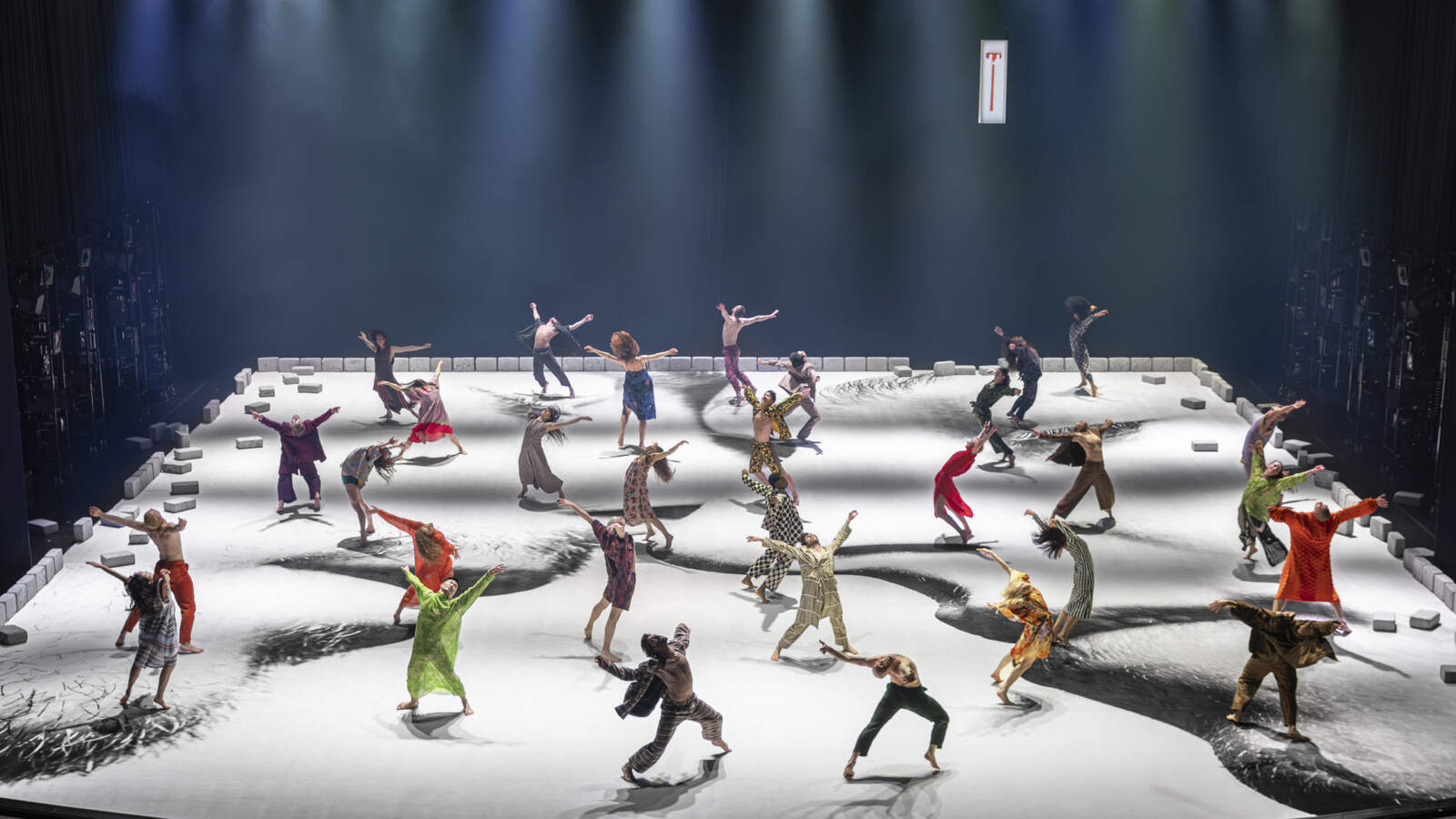 Flera dansare står på en scen med armarna utspridda och bakåtböjda huvuden. Golvet är en närbild av ett par med slutna ögon.